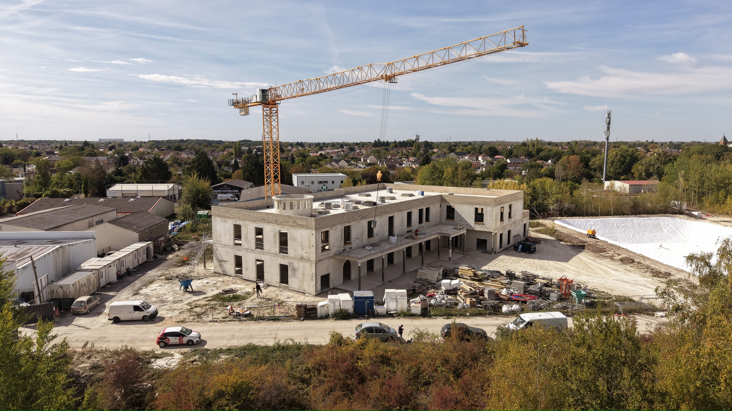 Vue aérienne du chantier de la Mosquée Ismail, avec le bâtiment en béton et la grue.